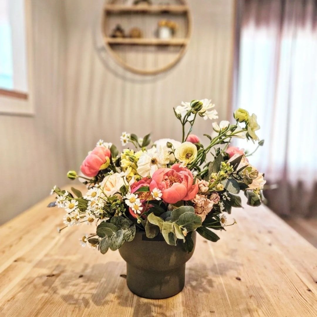 Ram de flors en gerro de ceràmica sobre taula de fusta